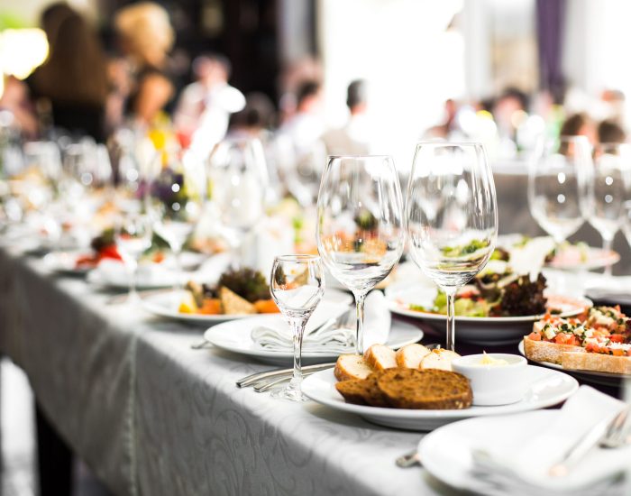 Sparkling glassware stands on long table prepared for wedding dinner